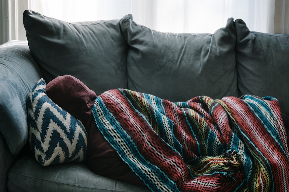 Person sick lying on a couch